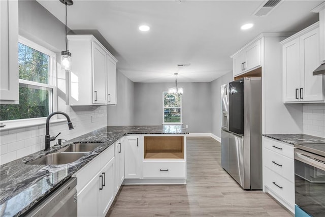 kitchen with white cabinetry, decorative light fixtures, stainless steel appliances, and a healthy amount of sunlight