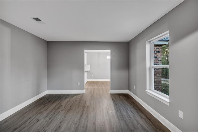 unfurnished room featuring dark wood-type flooring and a healthy amount of sunlight