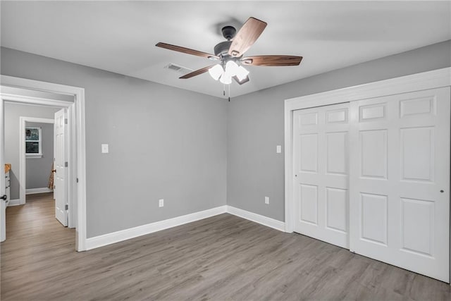 unfurnished bedroom featuring a closet, light wood-type flooring, and ceiling fan