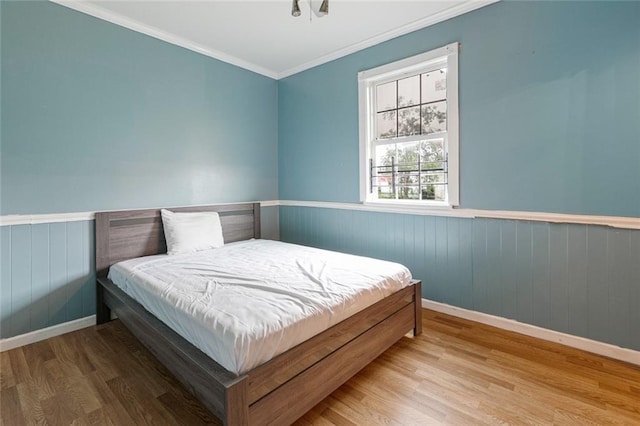 bedroom featuring light wood-type flooring and crown molding