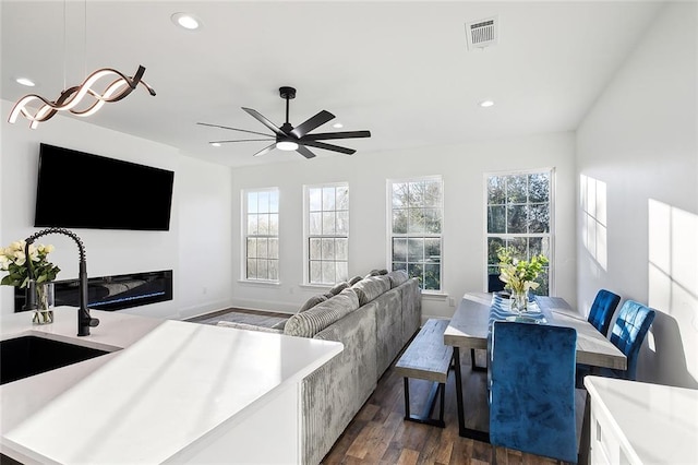 living room with sink, ceiling fan, and dark hardwood / wood-style flooring