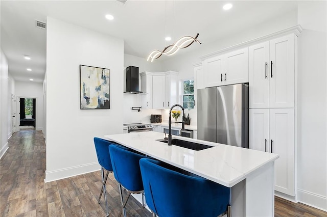 kitchen featuring a kitchen island with sink, white cabinetry, stainless steel appliances, and a healthy amount of sunlight