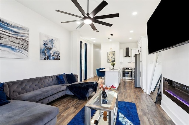 living room with ceiling fan and dark hardwood / wood-style flooring