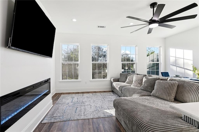 living room featuring dark hardwood / wood-style floors, a healthy amount of sunlight, and ceiling fan