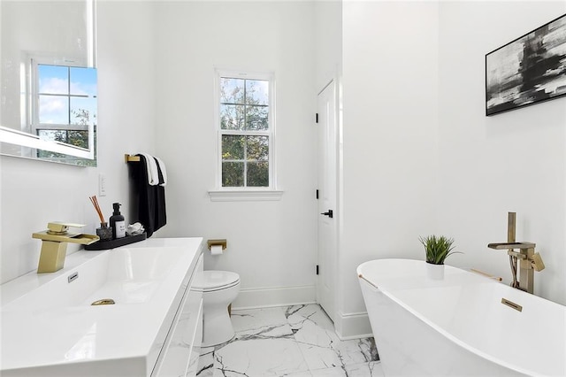 bathroom featuring vanity, toilet, and a washtub