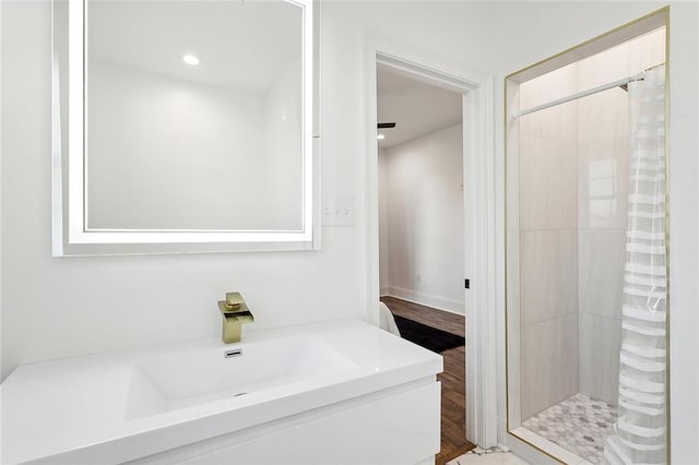 bathroom with wood-type flooring, sink, and curtained shower