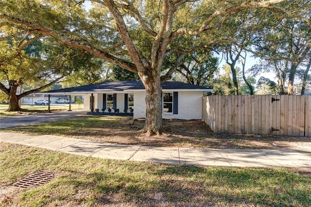 297 Nassau Dr, Slidell, LA 70458 - ranch-style house featuring brick siding, fence, aphalt driveway, and an attached carport