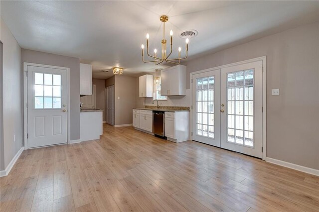 kitchen with dishwasher, light wood-type flooring, sink, pendant lighting, and white cabinets