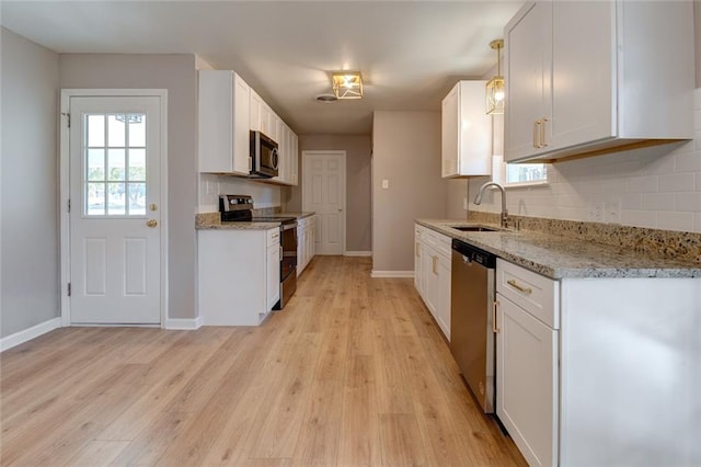 kitchen with sink, hanging light fixtures, light hardwood / wood-style floors, stainless steel appliances, and white cabinets