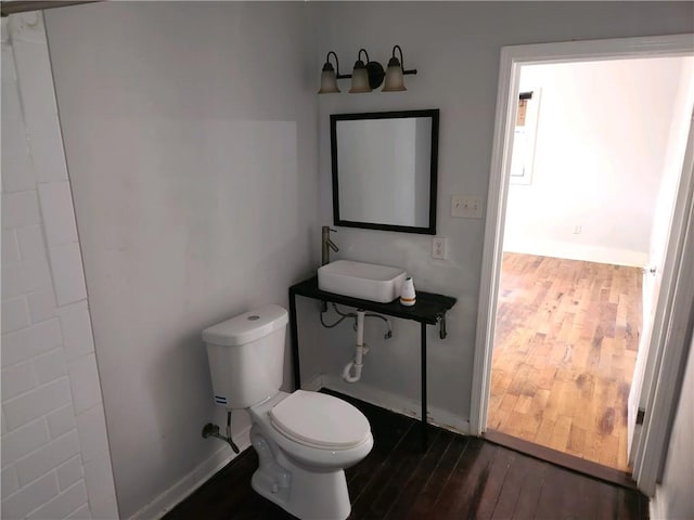 bathroom with toilet and wood-type flooring