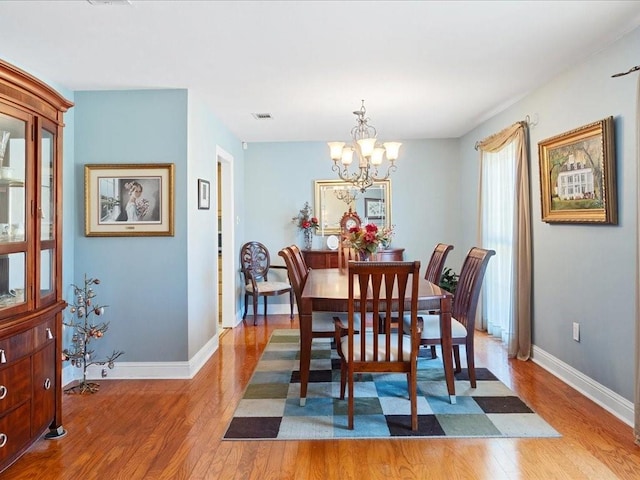 dining room featuring light hardwood / wood-style floors and a notable chandelier