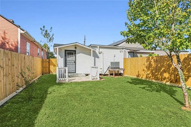 rear view of house featuring a lawn, a patio, and central air condition unit