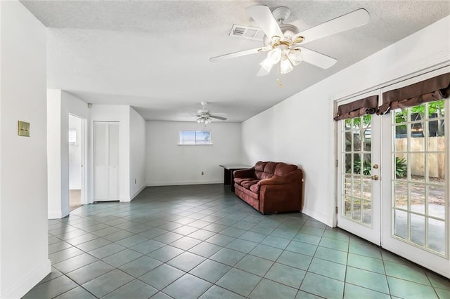 sitting room with tile patterned floors, ceiling fan, a textured ceiling, and plenty of natural light