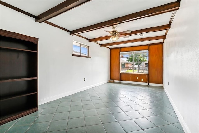 empty room with beamed ceiling, tile patterned floors, and ceiling fan