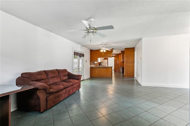 tiled living room featuring french doors, ceiling fan, and a textured ceiling