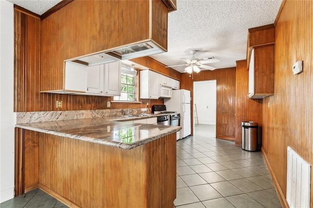 kitchen featuring white appliances, light tile patterned flooring, kitchen peninsula, white cabinetry, and ceiling fan