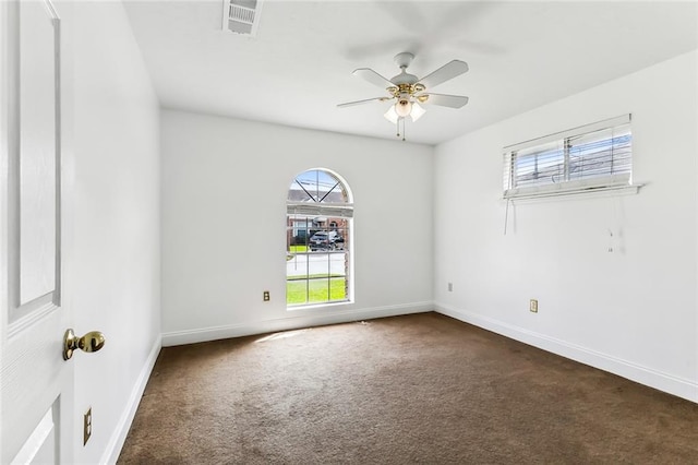 carpeted spare room featuring ceiling fan and a healthy amount of sunlight