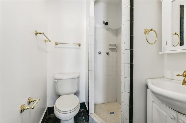 bathroom featuring a tile shower, toilet, tile patterned floors, and vanity