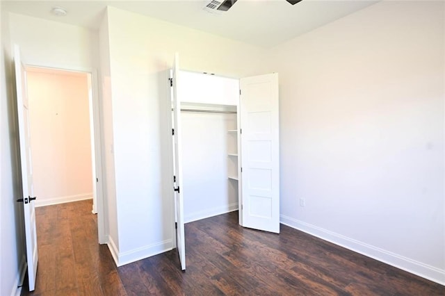 unfurnished bedroom with ceiling fan, a closet, and dark hardwood / wood-style flooring