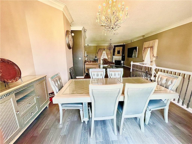 dining space featuring a chandelier, ornamental molding, a textured ceiling, and dark wood-type flooring