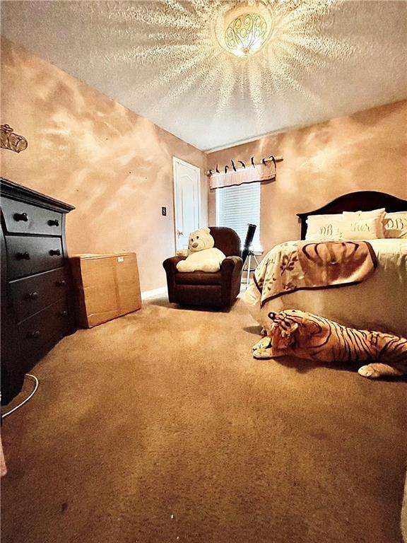 bedroom featuring carpet flooring and a textured ceiling