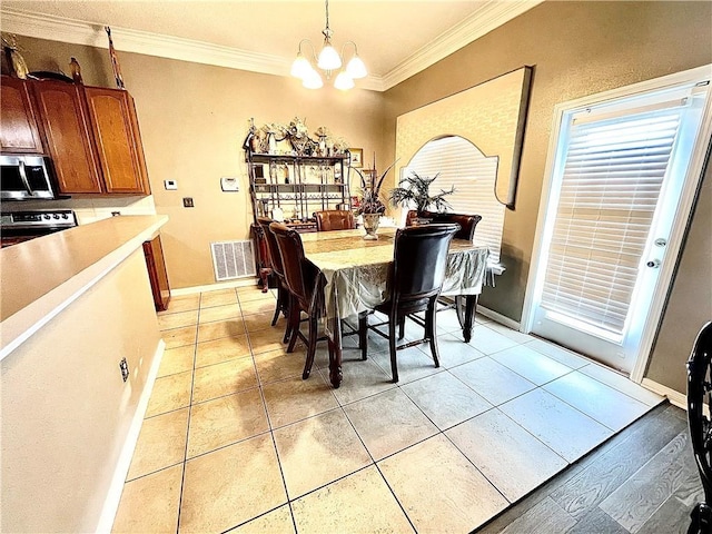 dining room featuring light tile patterned flooring, a notable chandelier, and ornamental molding