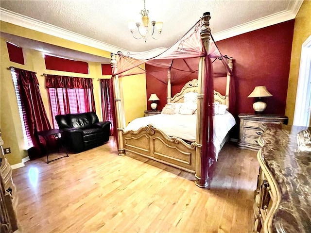 bedroom featuring a textured ceiling, wood-type flooring, ornamental molding, and an inviting chandelier