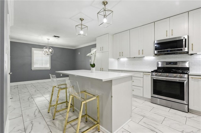 kitchen featuring a breakfast bar area, white cabinets, pendant lighting, appliances with stainless steel finishes, and tasteful backsplash