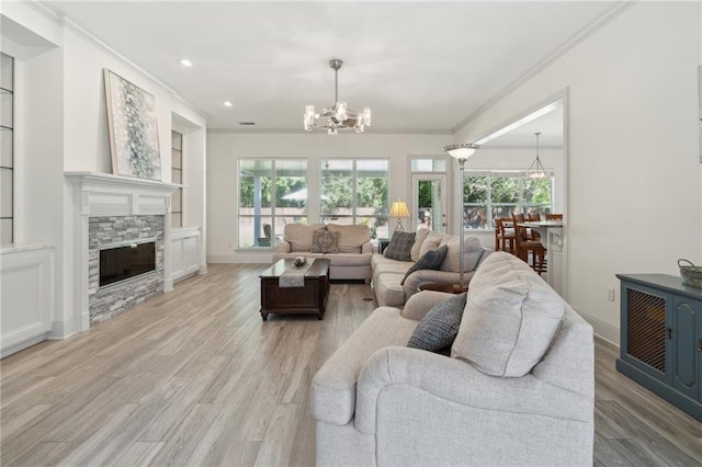 living room featuring a chandelier, ornamental molding, and a healthy amount of sunlight
