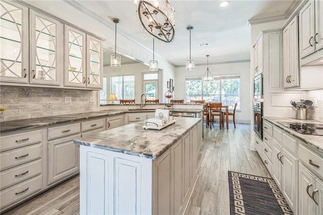 kitchen with crown molding, appliances with stainless steel finishes, a peninsula, tasteful backsplash, and glass insert cabinets