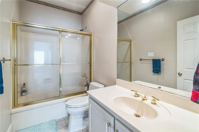 full bath featuring vanity, tile patterned floors, bath / shower combo with glass door, and toilet