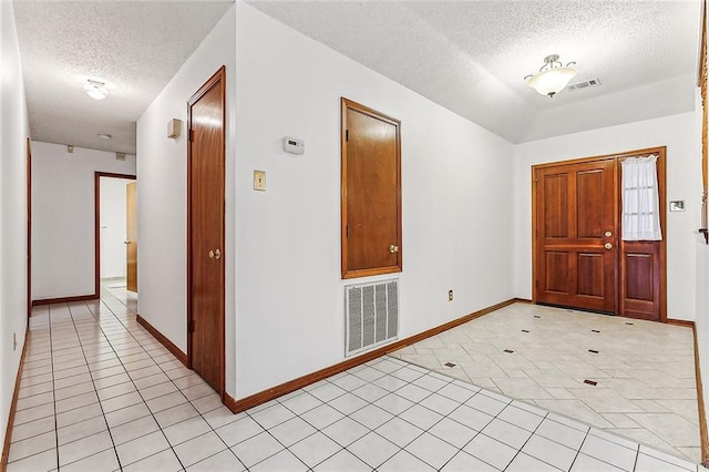 tiled foyer entrance with a textured ceiling