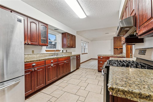 kitchen with appliances with stainless steel finishes, light stone counters, ventilation hood, sink, and light tile patterned floors