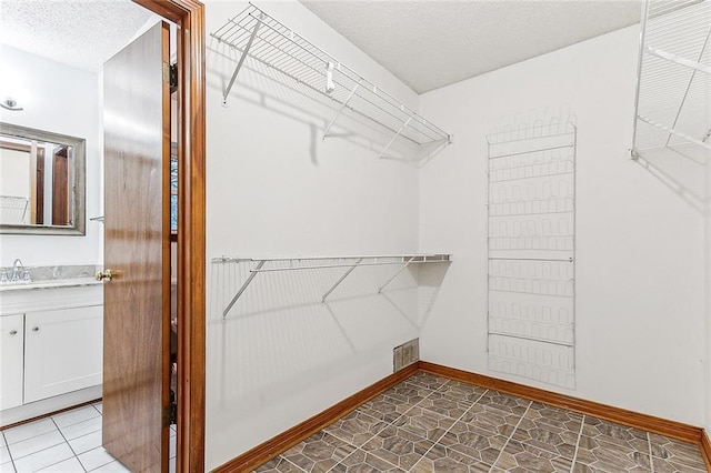 spacious closet with tile patterned flooring and sink