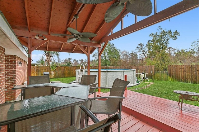 wooden deck with a lawn, ceiling fan, and a fenced in pool