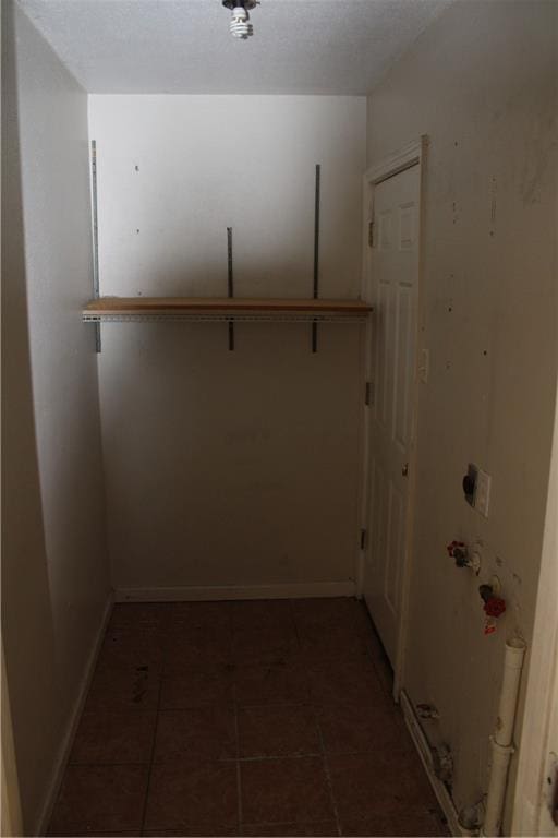 spacious closet featuring dark tile patterned flooring