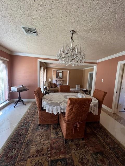 tiled dining area with crown molding, a textured ceiling, and a chandelier