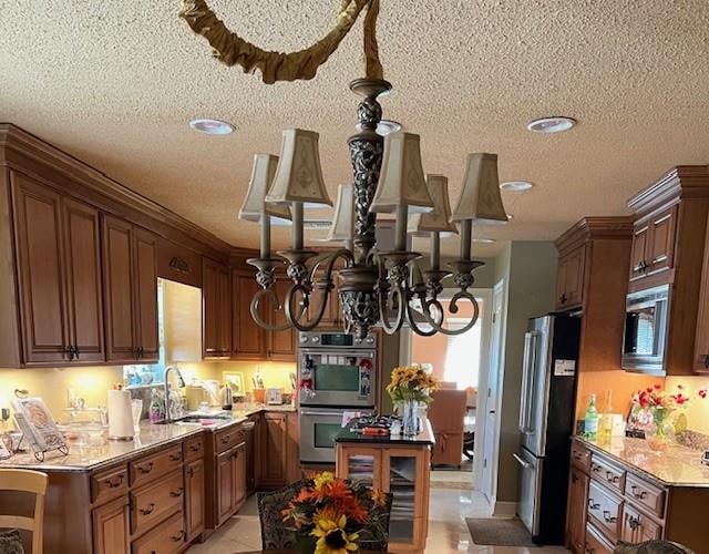 kitchen featuring a healthy amount of sunlight, appliances with stainless steel finishes, and a textured ceiling