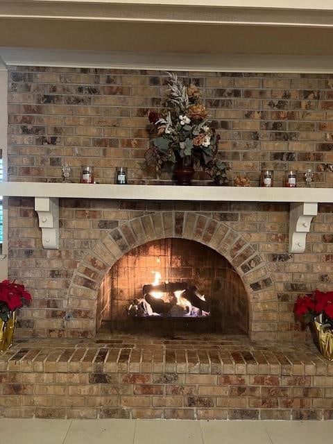 room details featuring a brick fireplace and tile patterned flooring