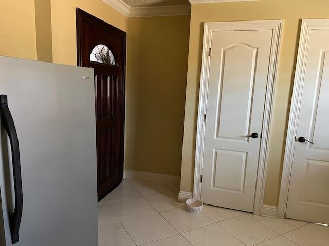 tiled entrance foyer featuring crown molding