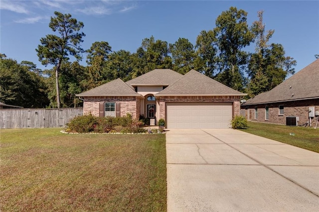 view of front of house with central air condition unit, a front lawn, and a garage