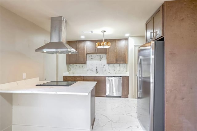 kitchen featuring kitchen peninsula, hanging light fixtures, island range hood, sink, and stainless steel appliances