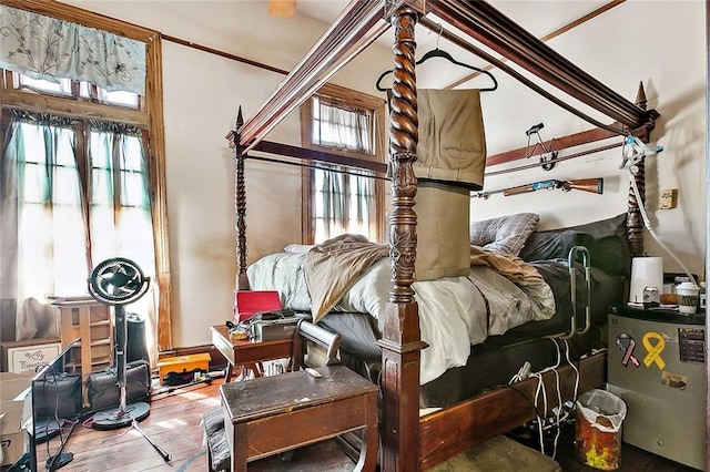 bedroom with wood-type flooring and fridge