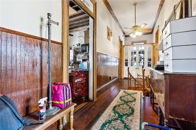 corridor with wood walls, ornamental molding, and dark hardwood / wood-style flooring