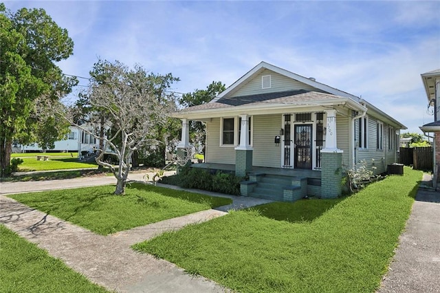 bungalow with a front lawn and covered porch