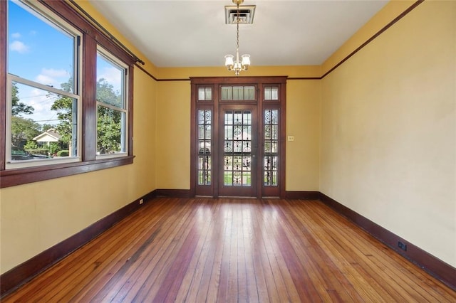 entrance foyer with hardwood / wood-style flooring and an inviting chandelier