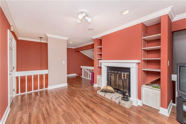 64 Fairway View Dr Unit 1, Hammond, LA 70401 - unfurnished living room with a brick fireplace, crown molding, baseboards, a textured ceiling, and wood finished floors