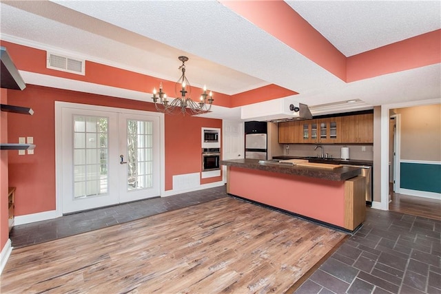 64 Fairway View Dr Unit 1, Hammond, LA 70401 - kitchen with brown cabinets, oven, baseboards, dark countertops, and freestanding refrigerator