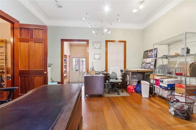 office area with wood-type flooring, crown molding, rail lighting, a raised ceiling, and a chandelier