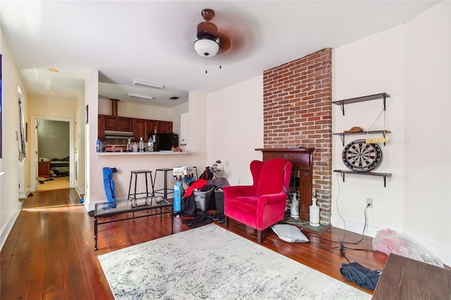 living room featuring ceiling fan and dark hardwood / wood-style flooring